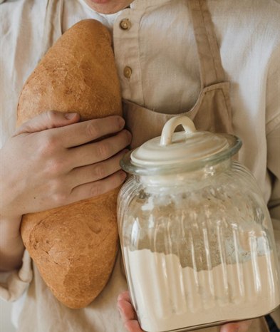 The baker smiles and looks at the loaves